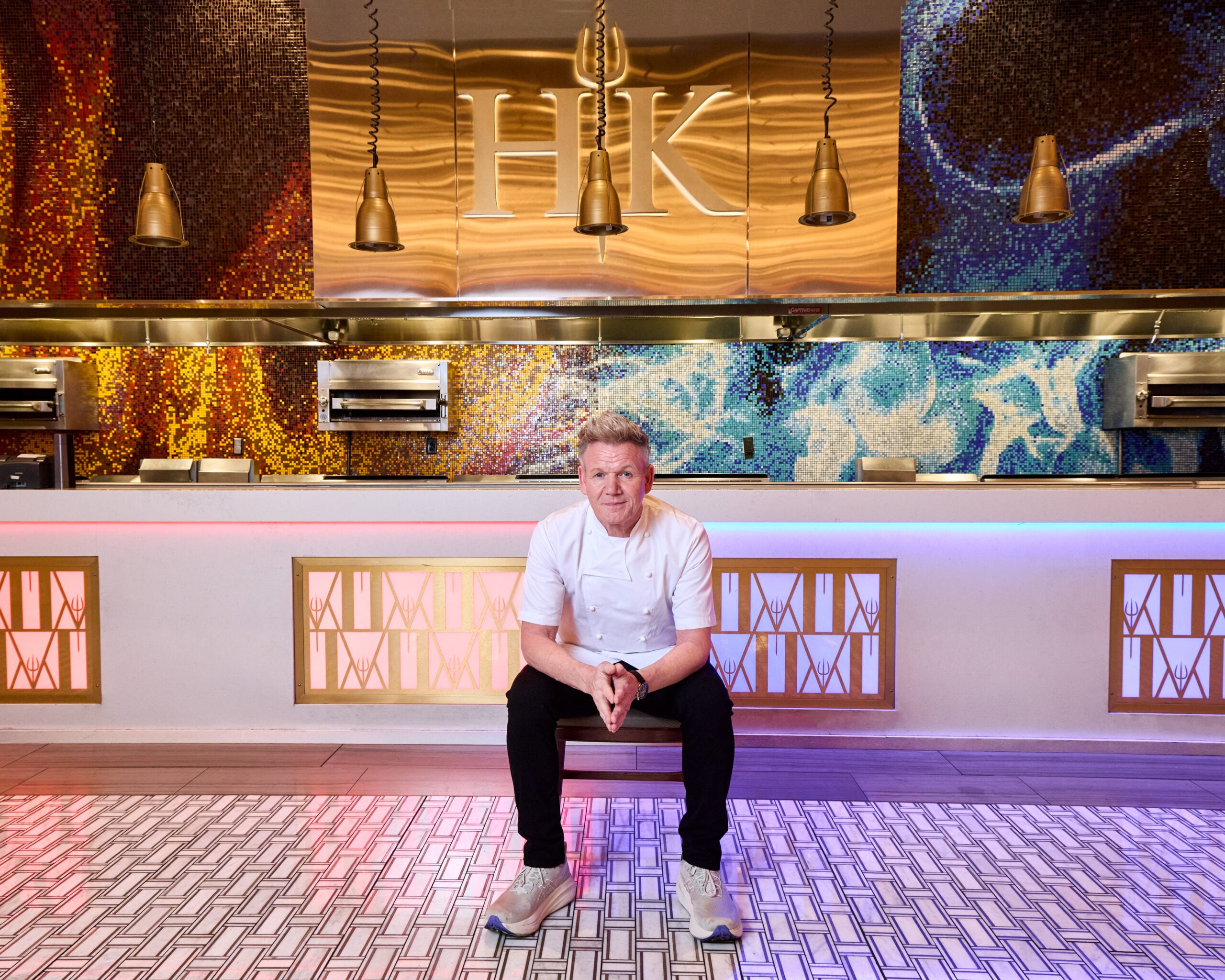 Gordon Ramsay sitting in the Hell’s Kitchen restaurant.