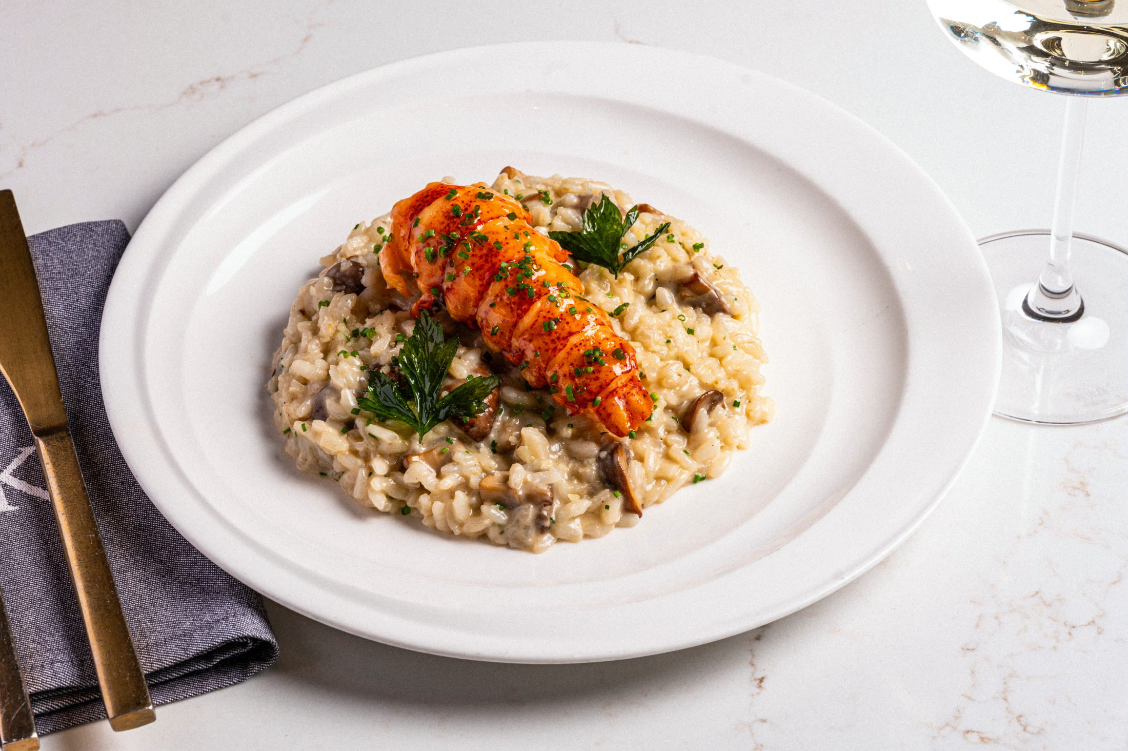 A lobster tail served on a bed of mushroom risotto.